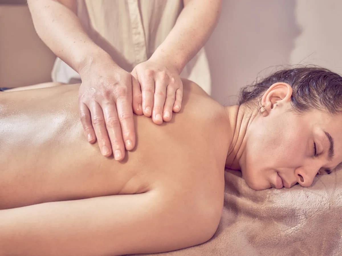 Pressions douces le long du dos pendant un massage aux huiles essentielles