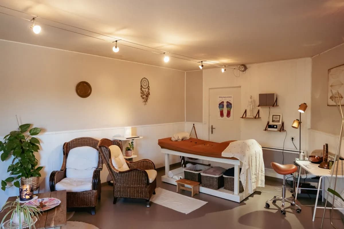 Salle de soin du cabinet Ephélise à Chalonnes-sur-Loire, avec la table de réflexologie et deux fauteuils